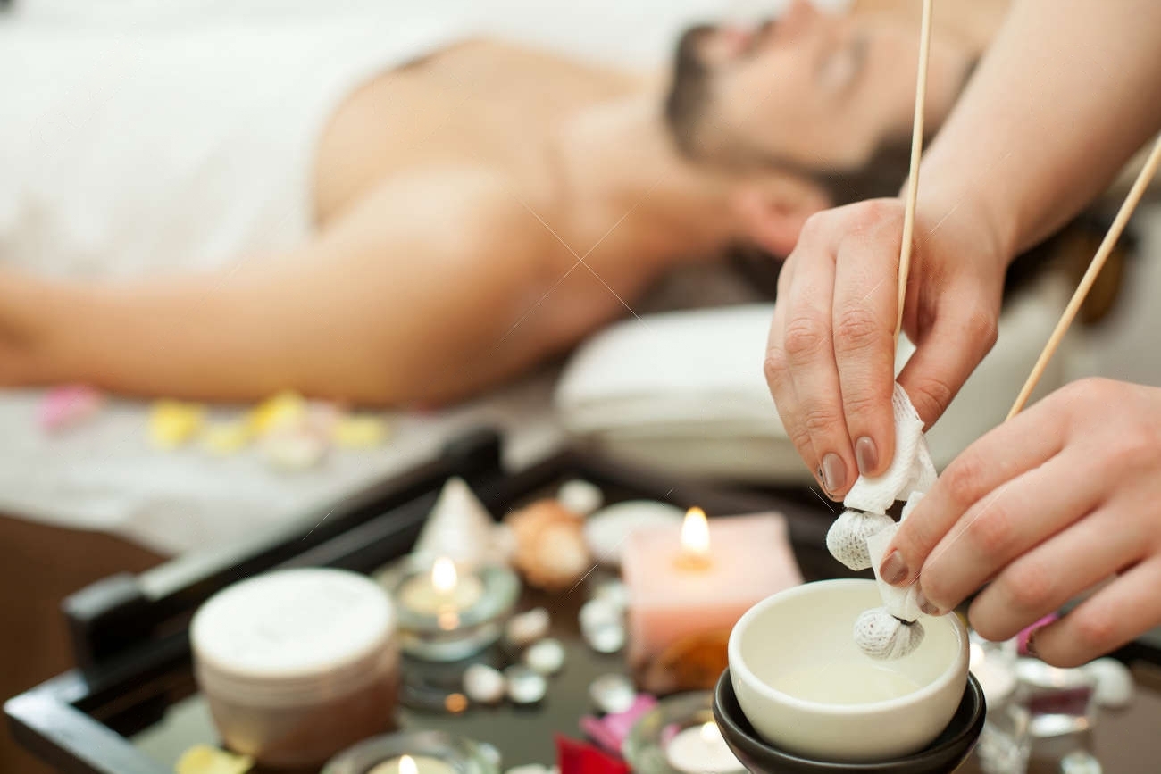 49993296-closeup-of-hands-of-a-masseur-young-man-being-massaged-with-an-herbal-compress-the-masseuse-is-transformed